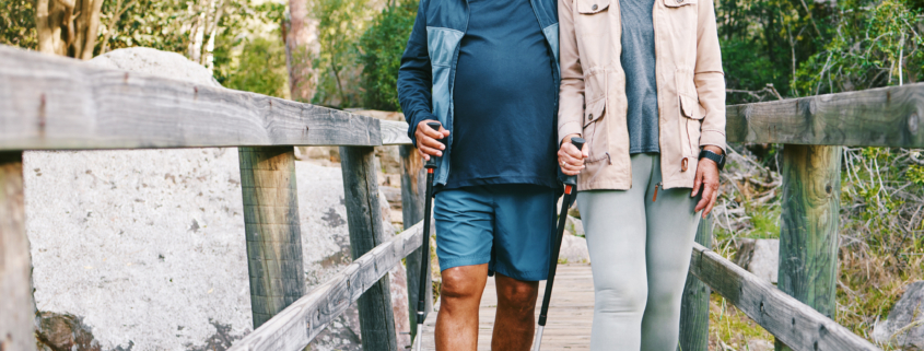 Senior couple hiking over a bridge.
