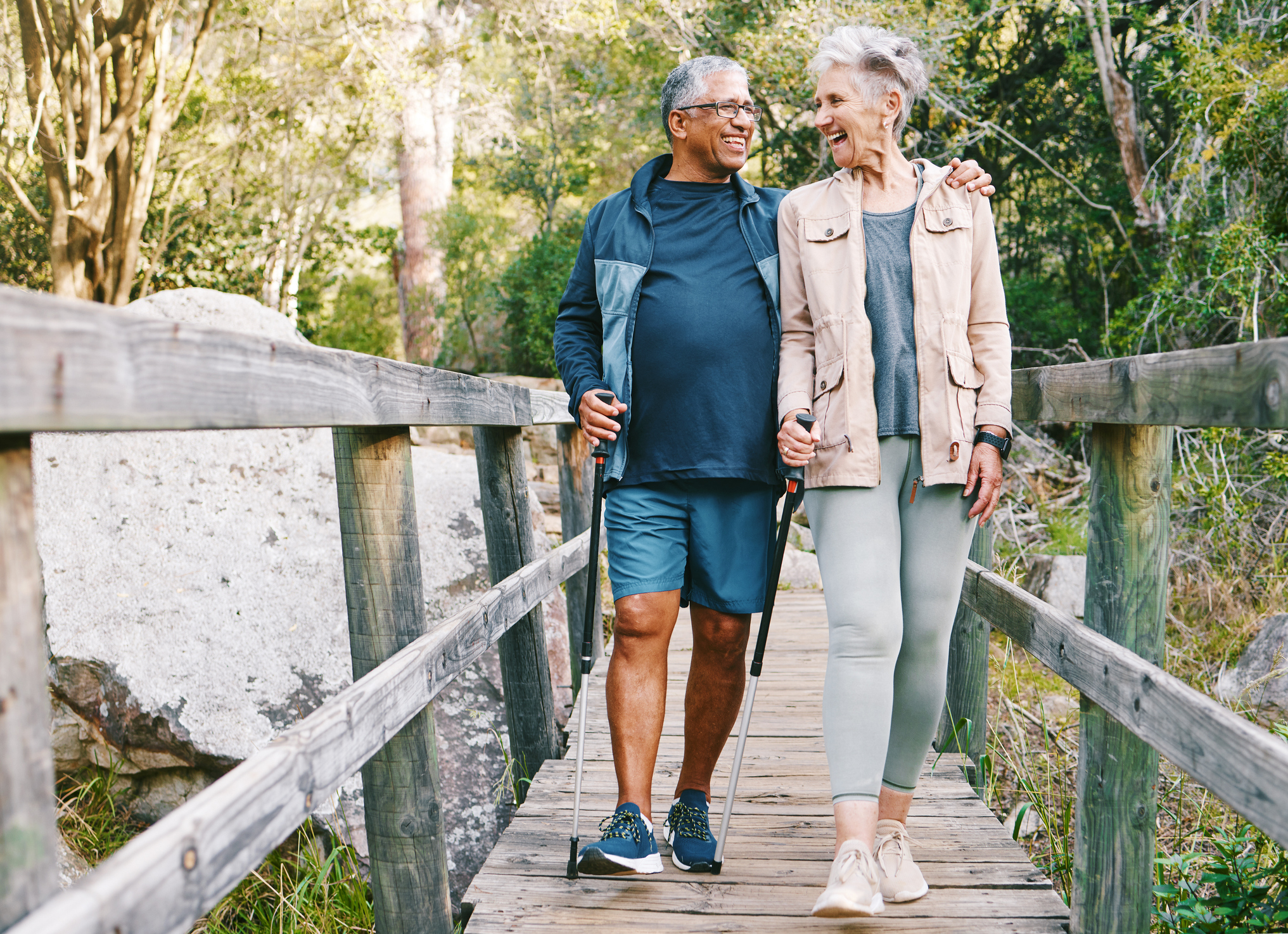 Senior couple hiking over a bridge.