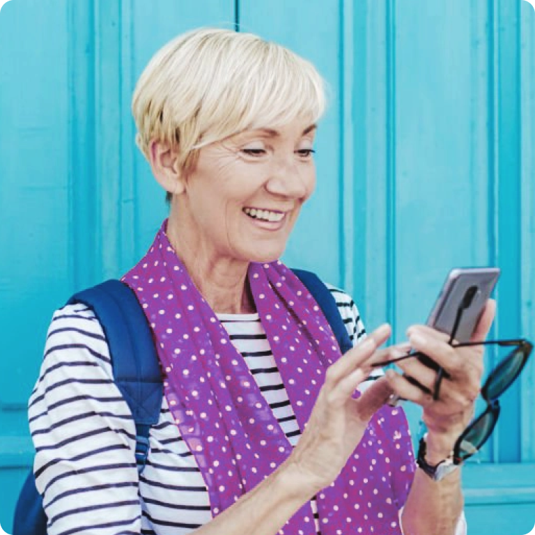 Smiling Woman Using Smartphone Against Vibrant Blue Background